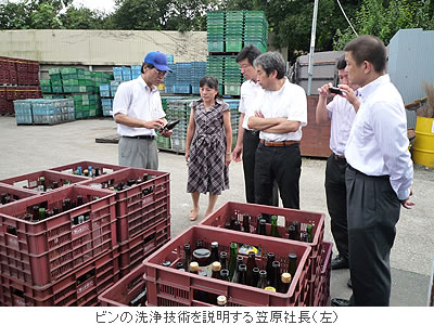 ビンの洗浄技術を説明する笠原社長(左)