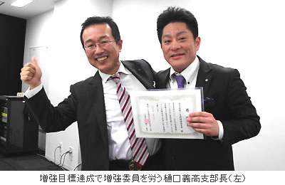 増強目標達成で増強委員を労う樋口義高支部長(左)