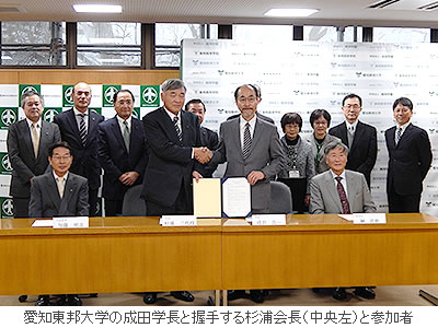 愛知東邦大学の成田学長と握手する杉浦会長（中央左）と参加者