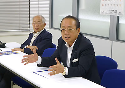 報告する村上氏(右)